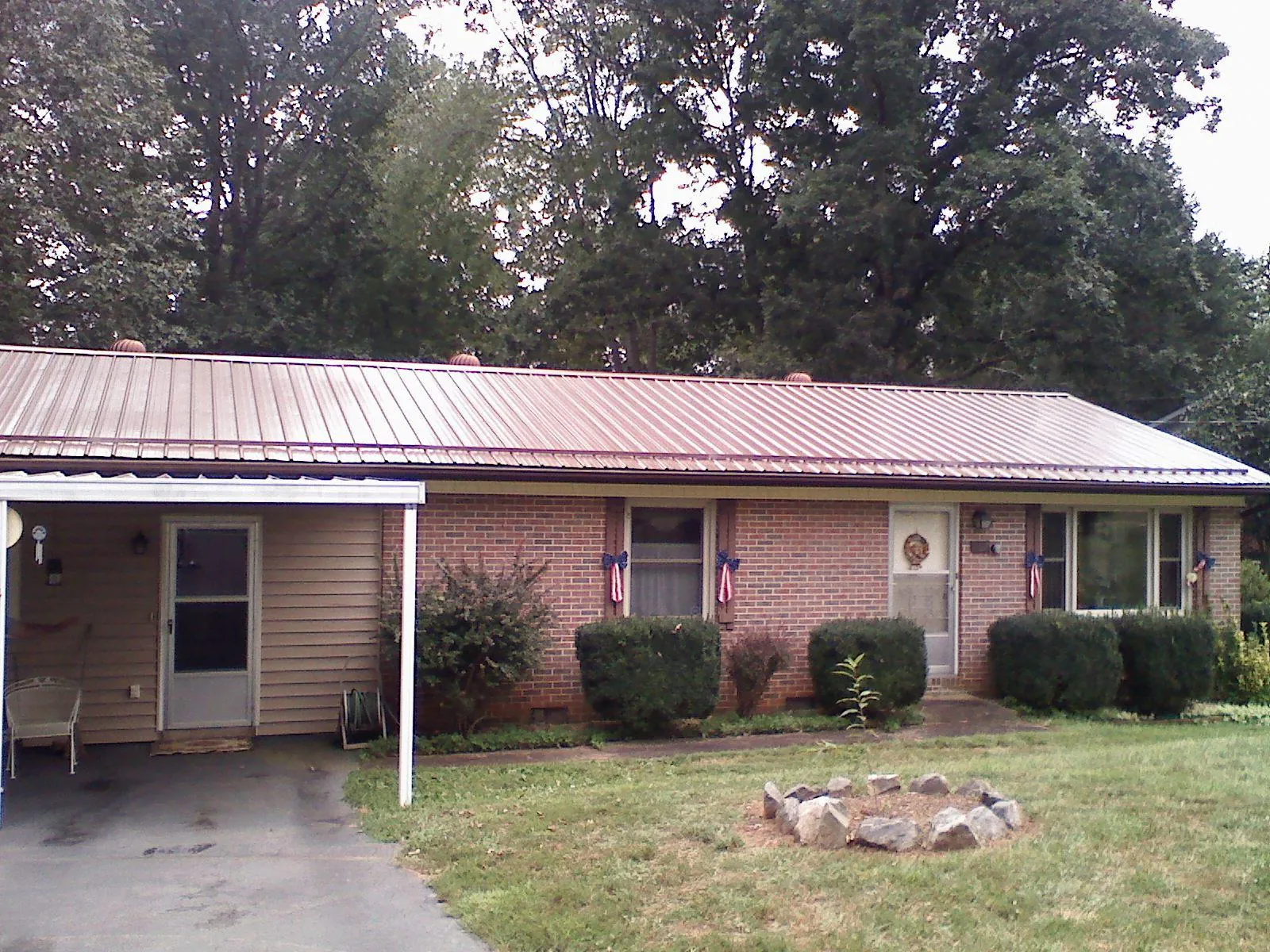 Bronze metal roof and carport on a brick ranch home — Roof Repair work by our crew in Candor
